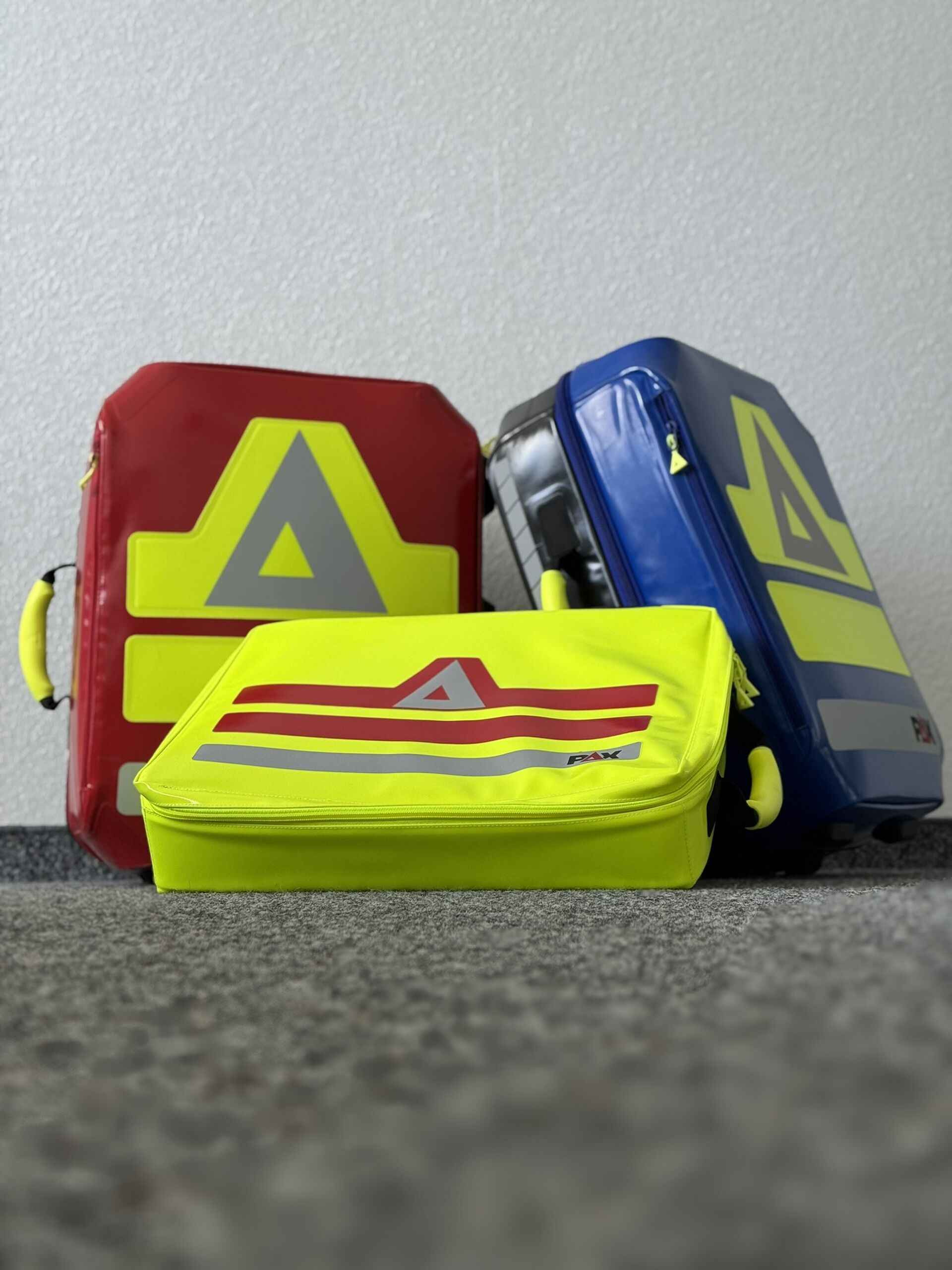 Drei Rettungsrucksäcke an einer Wand